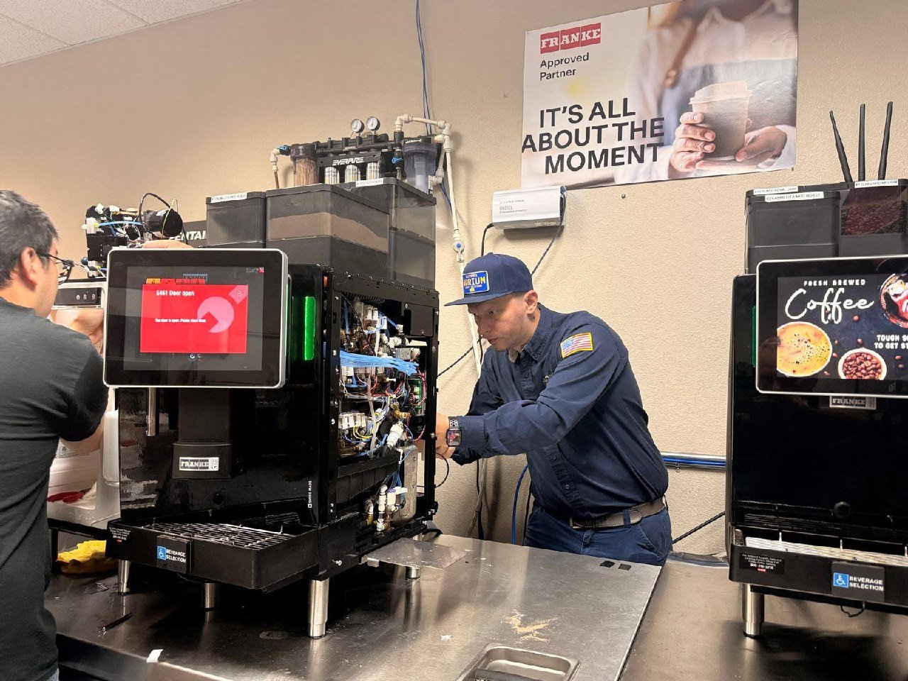 Andrew working beside an open Franke coffee machine in a training room