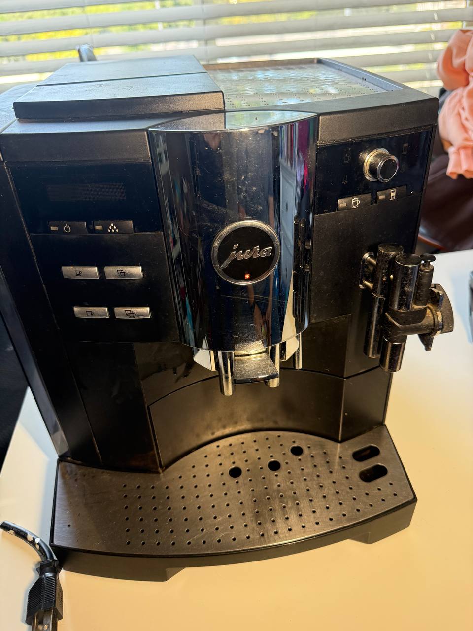 Jura black automatic bean-to-cup espresso machine on the bench, in for a water-line fault.